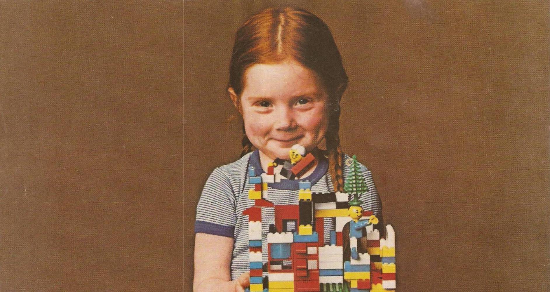 Girl from an 80s Lego commercial,
holding her fantastic creation with a smirk

