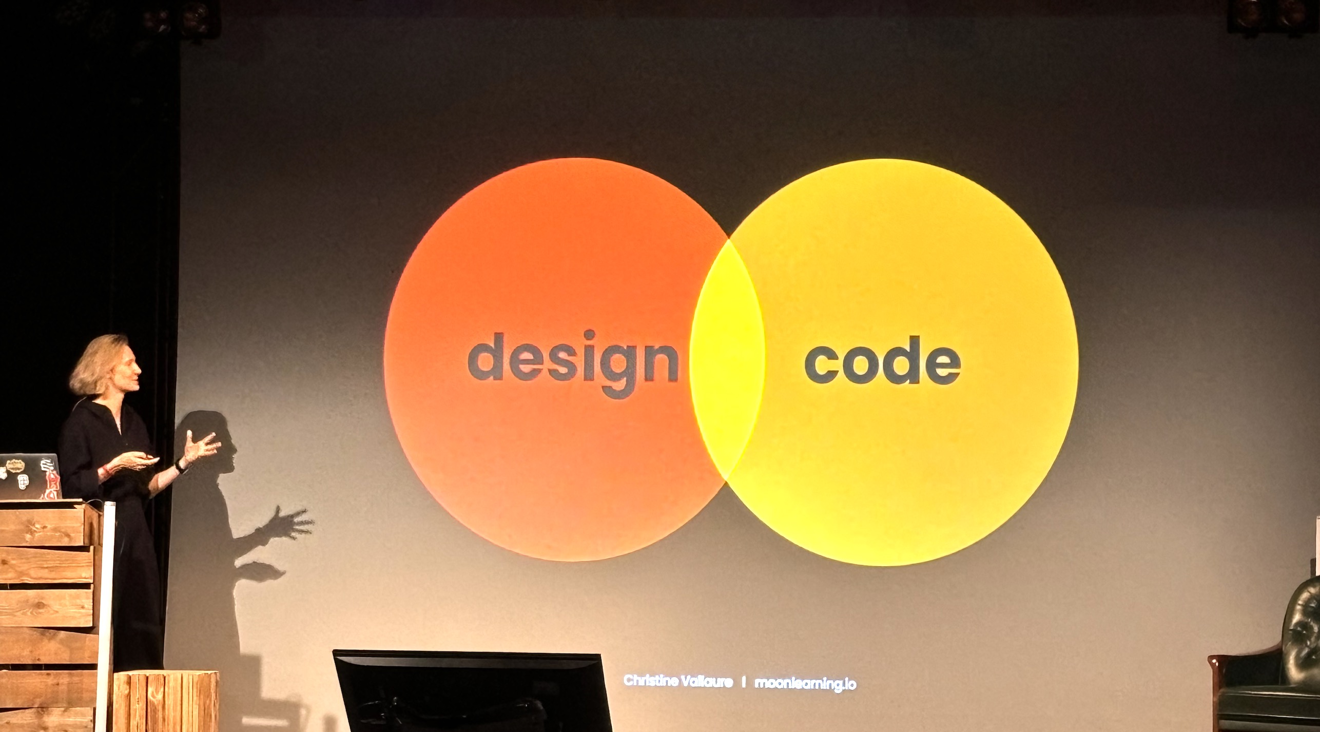 Christine in front of a slide with a venn diagram of code and design overlapping
