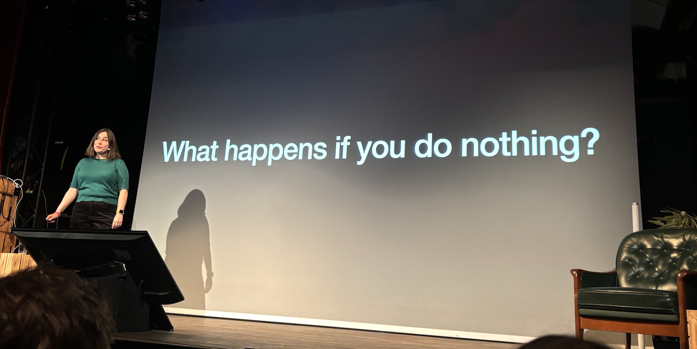 Sophie in front of a slide that asks what happens if you do nothing?
